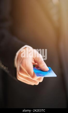 Paiement par carte. Photo rognée d'un homme d'affaires tenant une carte de crédit comme paiement. Banque D'Images