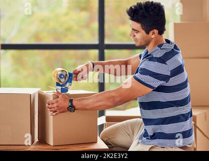 Emballage de la dernière boîte. Photo d'un jeune homme qui a tapé des boîtes le jour de son déplacement. Banque D'Images