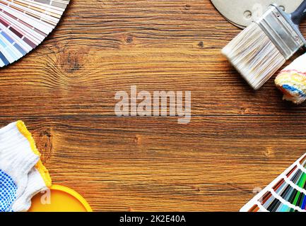 divers outils de peinture, accessoires et échantillons de couleur pour la rénovation de la maison sur fond de bois Banque D'Images