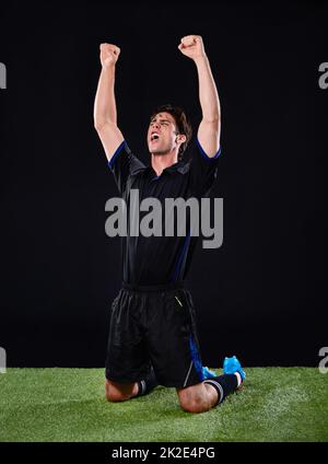 Il a marqué. Photo d'un joueur de football célébrant son but. Banque D'Images