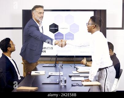 Son Ravi de vous rencontrer. Photo de deux hommes d'affaires se serrant la main dans une salle de réunion au travail. Banque D'Images
