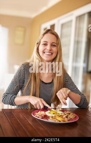 Pour bien commencer la journée. Prise de vue d'une jeune femme heureuse appréciant un repas à la maison. Banque D'Images