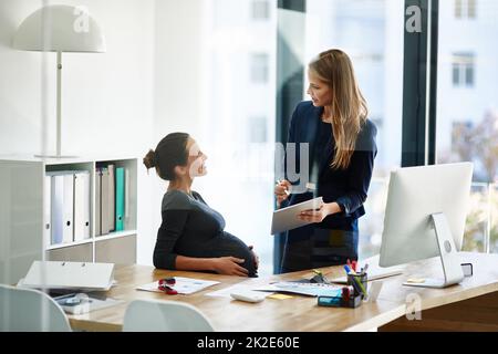 Ce bureau est brillant. Photo d'une femme d'affaires enceinte et d'un collègue utilisant une tablette numérique dans un bureau. Banque D'Images