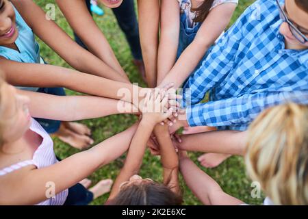 La bonté est puissance. Photo courte d'un groupe d'enfants qui se superposez les mains les unes aux autres. Banque D'Images