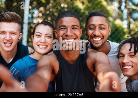 Elle sourit tout autour quand étaient ensemble. Portrait d'un groupe de jeunes sportifs qui prennent des selfies en plein air. Banque D'Images