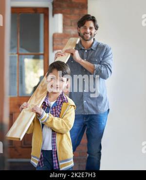 Il aime aider son père avec des améliorations à la maison. Un jeune garçon aidant son père avec l'amélioration de la maison. Banque D'Images