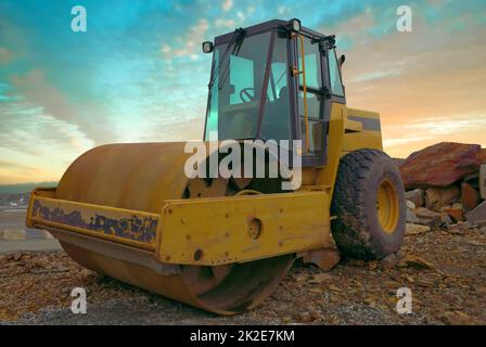 construction équipement lourd à roulettes jaune machine compacteur tandem vibrant ciel coucher de soleil Banque D'Images