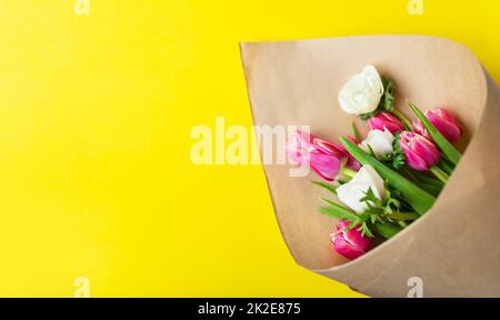 Bouquet rouge et blanc de fleurs de tulipes et d'anémones sur fond jaune. Avec espace de copie. Banque D'Images