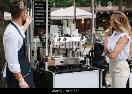 Barista man propose de choisir différents types de café à la cliente Banque D'Images