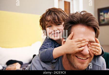 Père et son amusant. Photo d'un petit garçon couvrant les yeux de ses pères avec ses mains. Banque D'Images