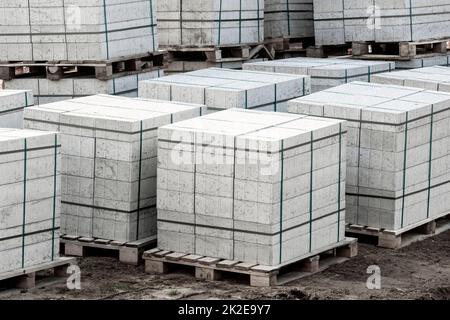 Carreaux de pavés en béton empilés sur des palettes en bois Banque D'Images