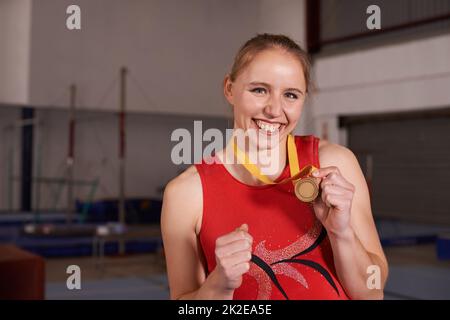 Je l'ai voulu, donc je suis allé pour ça. Portrait d'une jeune gymnaste montrant fièrement sa médaille. Banque D'Images