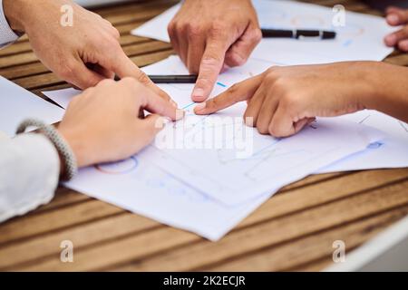 Tout cela sur la même page. Photo rognée d'un groupe de personnes en voyage d'affaires méconnues qui ont pointé des documents pendant une réunion dans la salle de réunion. Banque D'Images