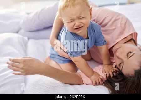 Il refuse simplement de faire une sieste. Photo courte d'une mère couchée avec son bébé garçon qui pleure à la maison. Banque D'Images