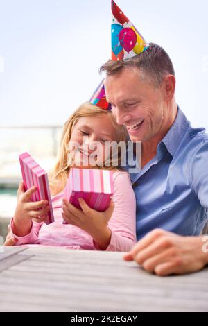 Gâcher sa princesse. Un petit cliché d'un homme heureux qui donne un cadeau à sa jeune fille à son anniversaire. Banque D'Images