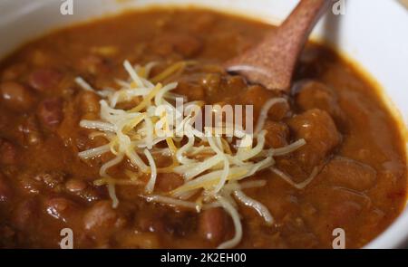 Bol de Chili avec haricots pinto sur la table avec poivrons et haricots secs en arrière-plan Banque D'Images