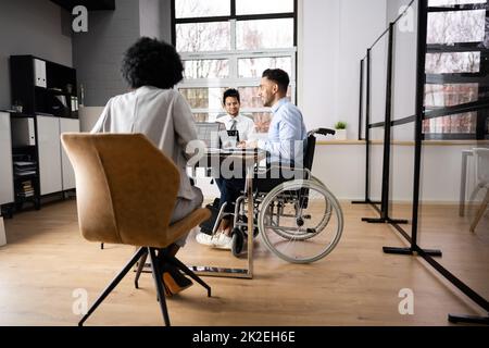 Homme d'affaires pour personnes handicapées assis au bureau avec ordinateur portable Banque D'Images