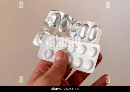 Utiliser inutilement des pilules n'est pas bon pour la santé, boîtes de pilules finies dans les mains d'une personne. Banque D'Images
