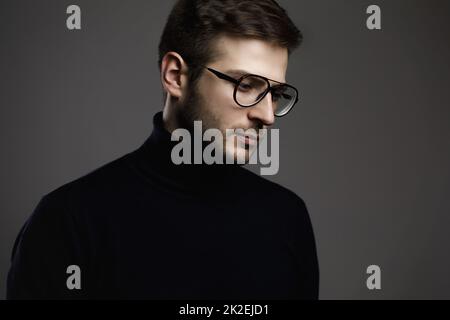 Jeune homme élégant portant des lunettes et un col roulé Banque D'Images