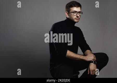 Jeune homme élégant portant des lunettes et un col roulé Banque D'Images