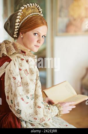 Seule dans ses chambres. Portrait d'une élégante noble femme lisant dans sa salle de palais. Banque D'Images