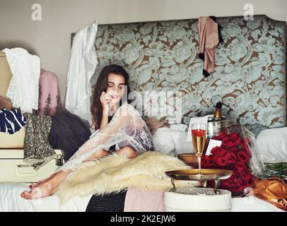 Les filles doivent se traiter elles-mêmes de temps en temps. Photo d'une belle jeune femme se reposant sur son lit tout en étant entourée de cadeaux qu'elle s'est achetée. Banque D'Images