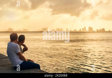 Terminer une journée parfaite comme il se peut. Photo courte d'un couple affectueux et mûr passant la journée au bord de la plage. Banque D'Images