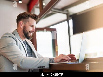 HES un homme sur une mission. Photo courte d'un homme d'affaires moderne utilisant son ordinateur portable dans un café. Banque D'Images