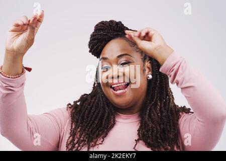 Shes dans la meilleure humeur aujourd'hui. Photo en studio d'une femme d'affaires attrayante se sentant gaie et dansant sur fond gris. Banque D'Images