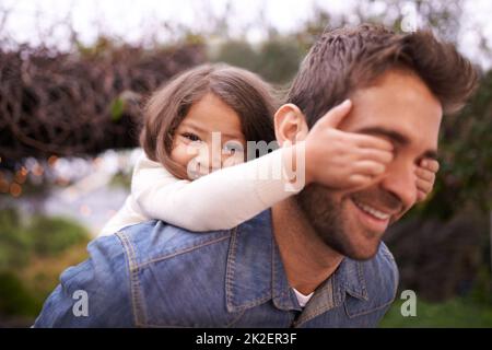 Devinez qui. Une petite fille et son père jouant à l'extérieur. Banque D'Images