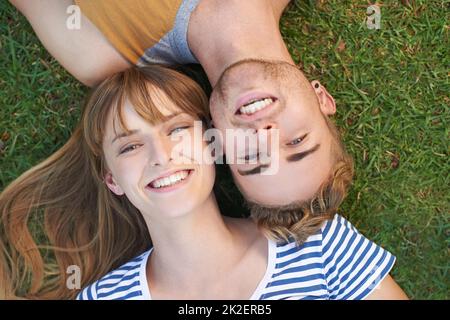 Détente dans le parc. Portrait d'un jeune couple heureux couché dans le parc. Banque D'Images