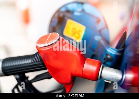 Injecteur de carburant rouge en gros plan. Gicleur de pompe à essence. Ravitaillement en carburant à la station-service. Faites le plein d'essence. Pompe à essence remplissage de la buse de carburant dans le réservoir de carburant de la voiture à la station-service. Crise des prix du pétrole. Banque D'Images