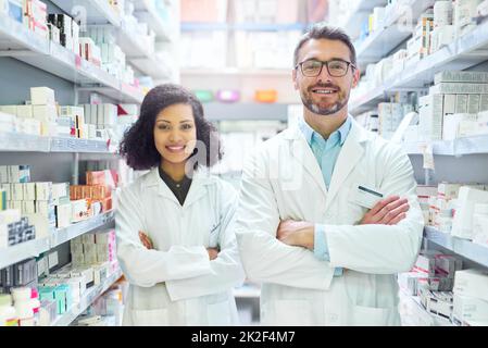 Si c'est bon pour vous, il l'a en stock. Portrait d'un homme mûr confiant et d'une jeune femme travaillant ensemble dans une pharmacie. Banque D'Images