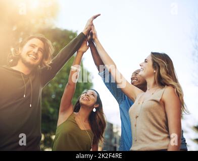 La force de la jeunesse. Photo d'un groupe de jeunes amis se donnant un haut cinq. Banque D'Images