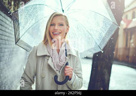 Ce temps ne me fera pas tomber. Portrait court d'une jeune femme attrayante marchant sous la pluie. Banque D'Images