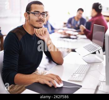 Confiant dans son rôle au sein de l'équipe. Photo rognée d'un jeune homme travaillant sur son ordinateur portable dans un bureau. Banque D'Images