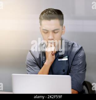 Décider des jours spéciaux. Photo courte d'un jeune homme attentionné travaillant sur son ordinateur portable. Banque D'Images