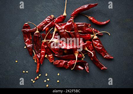 Augmentez la chaleur. Photo en grand angle de piments rouges séchés sur un comptoir de cuisine. Banque D'Images