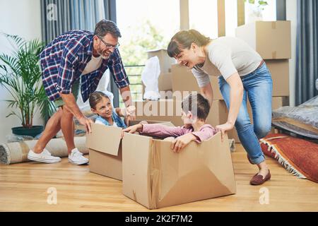 Faire participer la famille stimule le moral de la famille. Photo d'une famille heureuse s'amusant ensemble lors d'une journée en mouvement. Banque D'Images