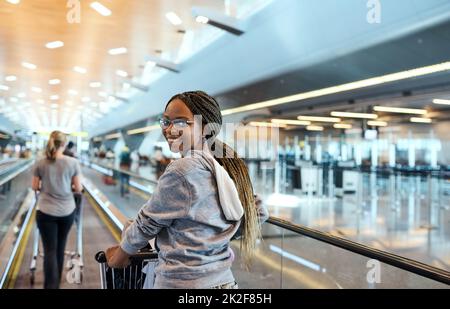 Enregistrement des bagages, nous venons. Portrait arrière d'une jeune femme attrayante marchant dans un aéroport. Banque D'Images