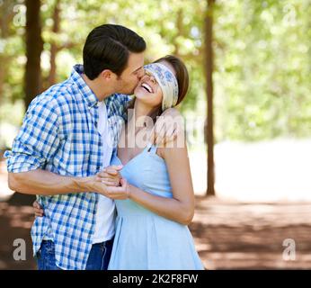 J'ai eu une surprise pour vous. Une jeune femme aveuglée riant avec son petit ami dans le parc. Banque D'Images