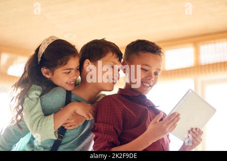 Les enfants d'aujourd'hui sont plus technophiles. Prise de vue de jeunes enfants à l'aide d'une tablette numérique à la maison. Banque D'Images