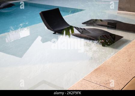 Table vide et piscine floue dans un complexe tropical Banque D'Images