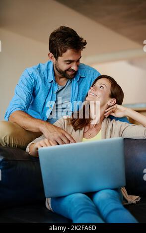 N'oubliez pas de m'identifier Photo courte d'un jeune couple affectueux se détendant sur le canapé à la maison. Banque D'Images