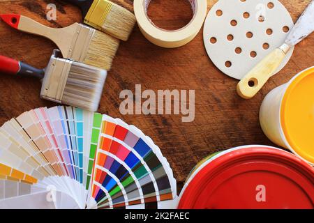 divers outils de peinture, accessoires et échantillons de couleur pour la rénovation de la maison sur fond de bois Banque D'Images