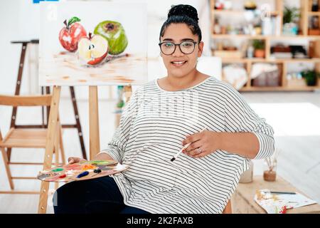 La vie est l'art de dessiner sans gomme. Portrait rogné d'un jeune artiste attrayant assis seul dans le studio et tenant une palette pendant un cours d'art. Banque D'Images