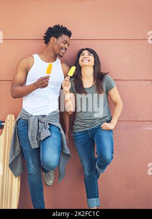 Je pouvais vous écouter rire toute la journée. Photo d'un jeune couple heureux mangeant des succés de glace ensemble. Banque D'Images