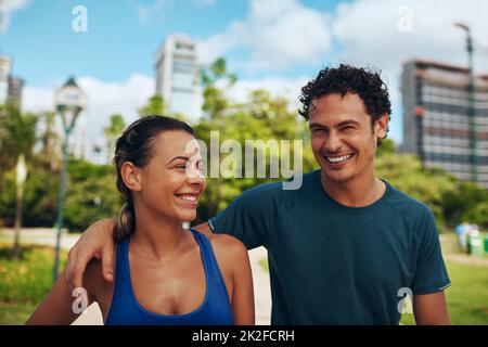 Travailler ensemble nous a rendu plus heureux. Photo courte d'un jeune couple sportif affectueux travaillant ensemble en plein air. Banque D'Images