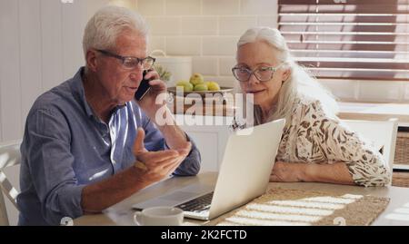 Il y a des frais supplémentaires que je ne reconnais pas. Photo d'un couple senior assis ensemble dans leur cuisine à la maison et calculant leurs finances. Banque D'Images