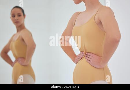 Je suis en conflit ici. Photo d'une jeune danseuse de ballet inspectant sa figure dans un miroir pendant une répétition. Banque D'Images